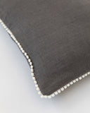 Cushion cover with pom poms in Charcoal gray