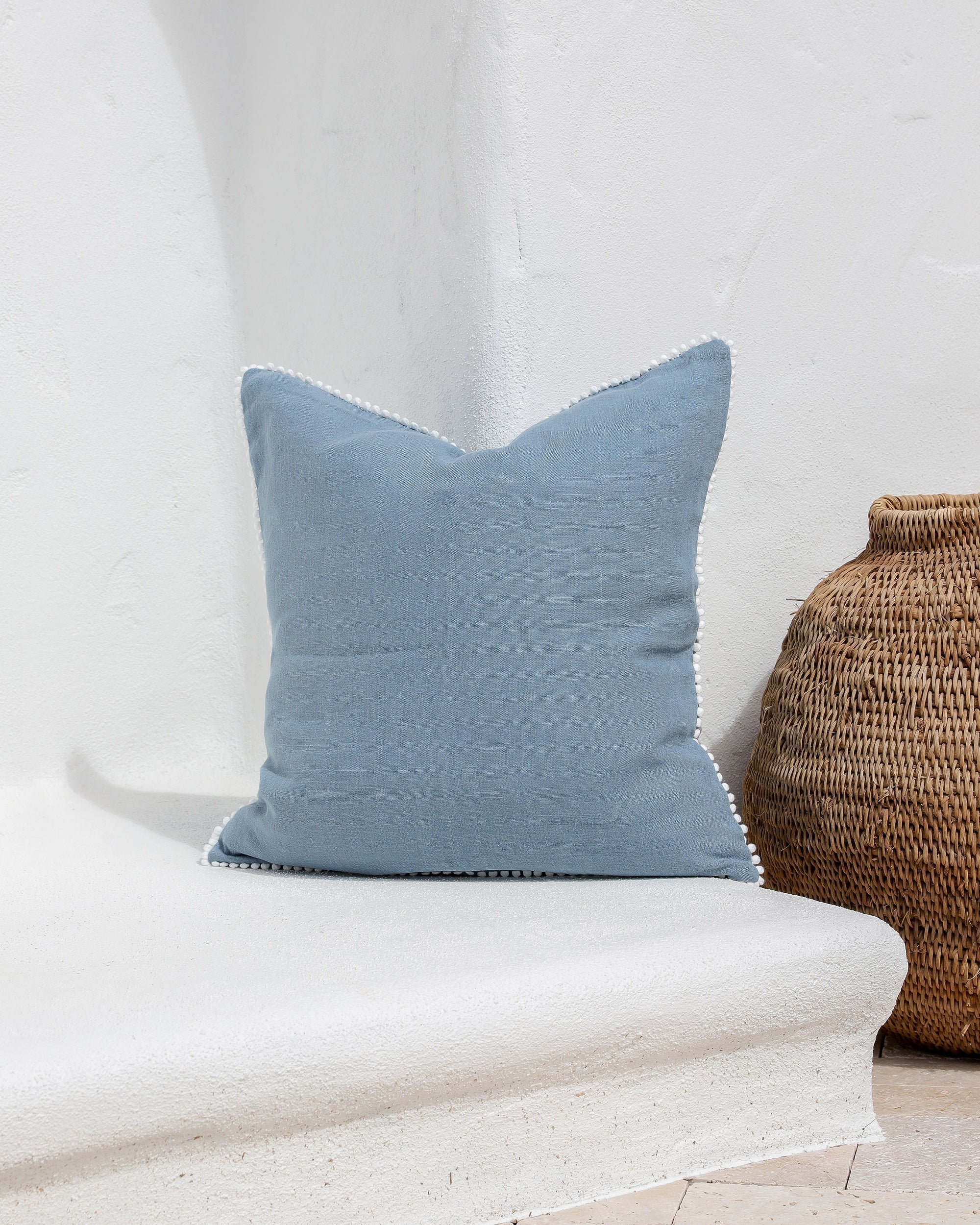 Cushion cover with pom poms in Gray blue